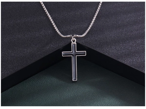 Detailed close-up of a silver stainless steel cross pendant with black enamel inlay
