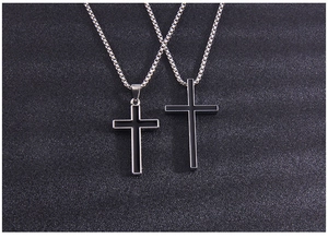 Detail view of two vintage punk cross necklaces with black enamel and silver box chains