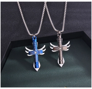 Detail von silbernen und blauen Kreuzflügelanhängern mit Kiss-Gravur an Metallkette
