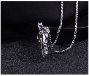 Close-up of retro silver motorcycle pendant with chunky stainless steel square box chain