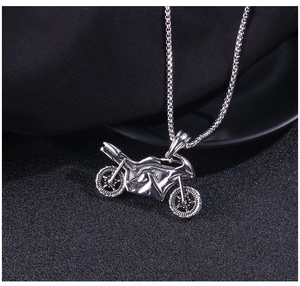Macro view of detailed motorcycle pendant with engine and wheel textures on a steel chain