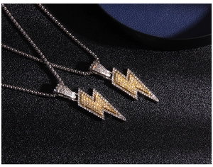 Macro shot of hip hop lightning pendants with iced out rhinestones on black background