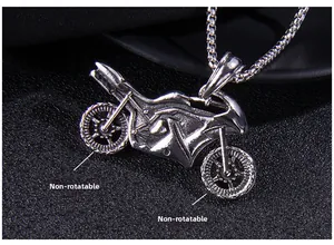 Detail of vintage silver motorcycle pendant featuring fixed wheels and industrial texture