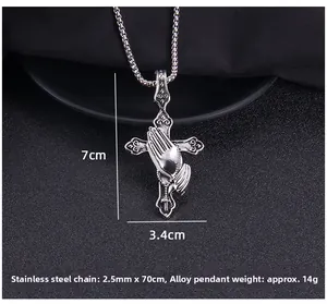 Detail view of prayer hands cross pendant measuring 7cm by 3.4cm on a long chain