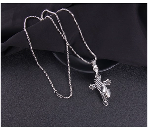 Macro view of vintage stainless steel cross and praying hands pendant necklace