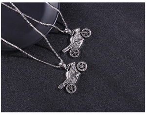 Close-up of vintage silver motorcycle pendants with detailed metal textures on dark background