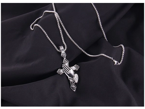 Macro detail of gothic praying hands relief on vintage stainless steel cross pendant