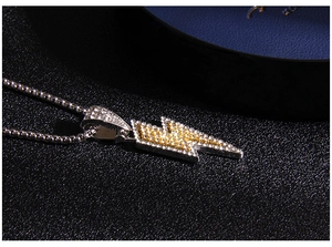 Close-up of hip-hop lightning pendant with gold and silver tones and iced-out rhinestones