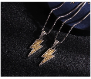 Macro detail of lightning pendants featuring white and gold zircons with silver box chain