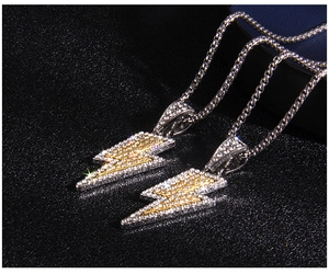 Macro detail of iced-out lightning pendants with dual-tone yellow and white crystals