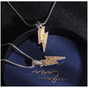 Detail of hip hop lightning pendants with box chain featuring gold and silver stone setting