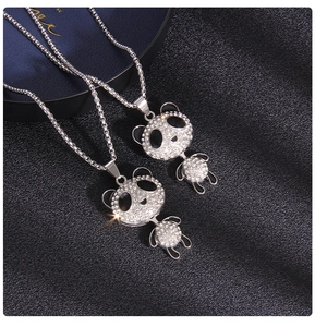 Macro view of crystal-encrusted panda necklaces with black enamel details on a leather surface