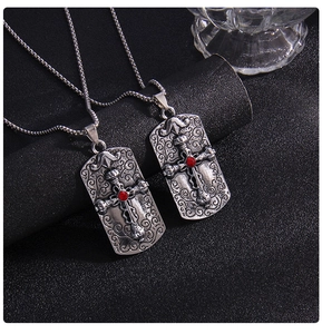 Détail de colliers croix carrés avec gemmes rouges et reliefs en argent vintage