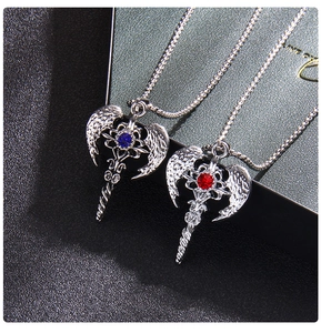 Detailed macro view of punk angel wing axe pendants with red and blue inlaid crystals