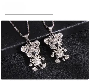 Détail de pendentifs tigre en argent avec strass brillants et lignes gravées noires