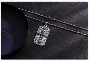 Vue détaillée du collier pendentif croix argenté avec une pierre de zircone rouge