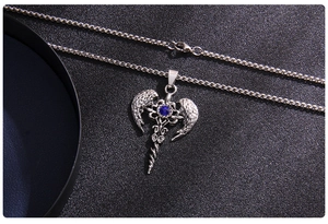 Close-up of vintage titanium steel angel wing cross pendant with blue rhinestone