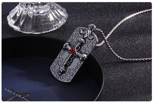 Détail macro du pendentif croix gothique avec gravures de crâne et gemme rouge