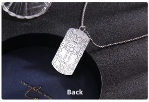 Gros plan du pendentif croix en argent vintage avec gravures florales et chaîne à billes