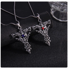 Detail of gothic sword cross necklaces with blue and red gems on black background