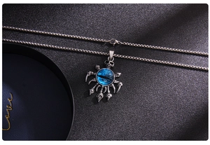 Macro shot of silver titanium steel necklace with blue evil eye skull claw pendant