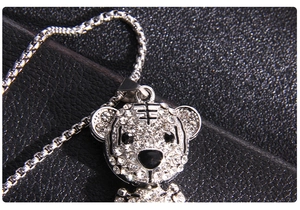 Détail du pendentif tigre serti de zircons brillants sur un fond en cuir marron