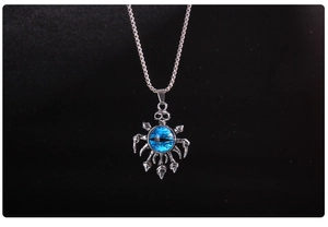 Macro detail of gothic skull pendant with vibrant blue evil eye and silver claw structure