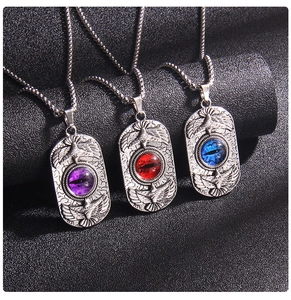Detail view of retro eagle pendants with purple, red, and blue evil eye stones on metal chains