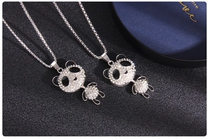 Close-up of sparkling panda pendant necklaces featuring clear crystals and black enamel