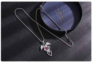 Détail du pendentif gothique en forme de chauve-souris et croix avec pierre rouge