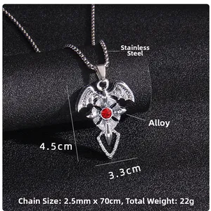Macro d'un pendentif croix chauve-souris en acier avec pierre rouge sur fond noir