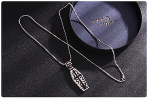 Gothic coffin pendant necklace with skull and cross details on dark leather background