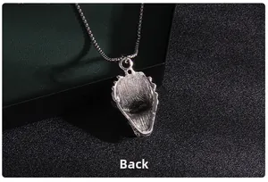 Macro detail of the brushed silver metal back view of animal pendant with long chain