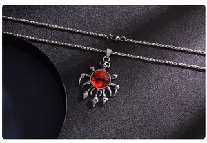 Macro shot of punk skull necklace with a red evil eye pendant and sharp gothic claws
