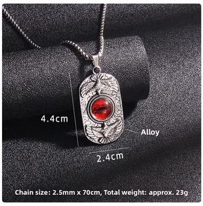 Macro shot of silver-tone alloy evil eye pendant with eagle relief and red gemstone