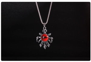 Macro shot of gothic stainless steel skull pendant featuring a deep red eyeball detail