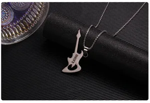 Detail of guitar pendant backside showing S.Steel engraving on dark textured background