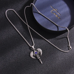 Silver angel wing cross necklace with blue crystal on a textured black background