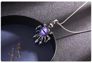 Close-up of titanium spider claw necklace with purple evil eye and skull pendant detail