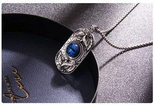 Close-up of Turkish Evil Eye pendant with eagle emblem on a silver square link chain