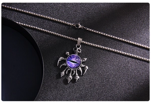 Macro detail of gothic skull pendant with purple evil eye on a silver box chain