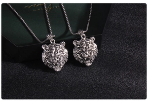 Detailed close-up of a silver tiger head pendant with intricate metallic textures and mane