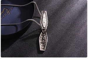 Macro shot of gothic coffin pendant opening to reveal a detailed skull relief