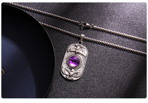 Detailed view of punk style stainless steel necklace with eagle relief and purple eye stone
