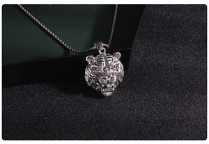 Close-up of a vintage silver tiger head pendant necklace with punk style engraving