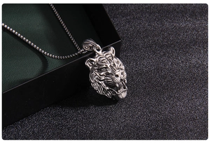 Close-up of a vintage silver tiger head pendant with detailed realistic metal carving