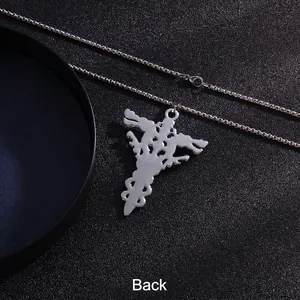 Silver stainless steel double dragon cross necklace back view on dark textured background