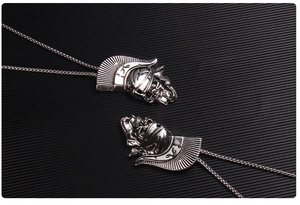 Vue macro de deux pendentifs crâne de guerrier gothique argentés avec chaînes en métal