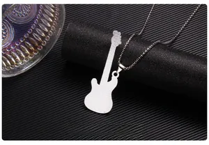 Macro shot of silver guitar pendant with intricate grid texture on a black cylinder