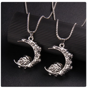 Détail macro du pendentif lune et crâne gothique avec texture de cratère sur support noir